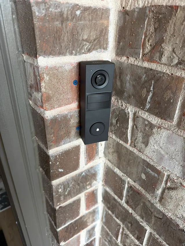 Video doorbell mounted on a brick wall